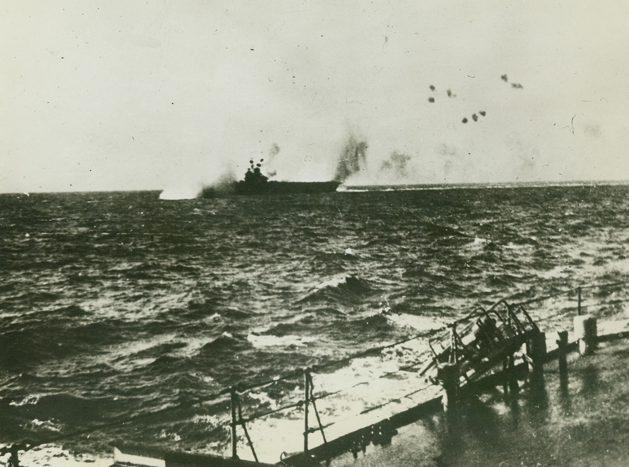 Bombing Of HMS Illustrious In Mediterranean (2), 10/27/41  Mediterranean – German Dive Bombers begin to find their range and hits are scored on the British Aircraft Carrier Illustrious, which was their main target during six attacks in the Mediterranean. The vessel made its way to an American port, where it is undergoing repairs. This exclusive picture is the second of a sequence of three, received by clipper today, passed by British Censor. Credit: ACME;