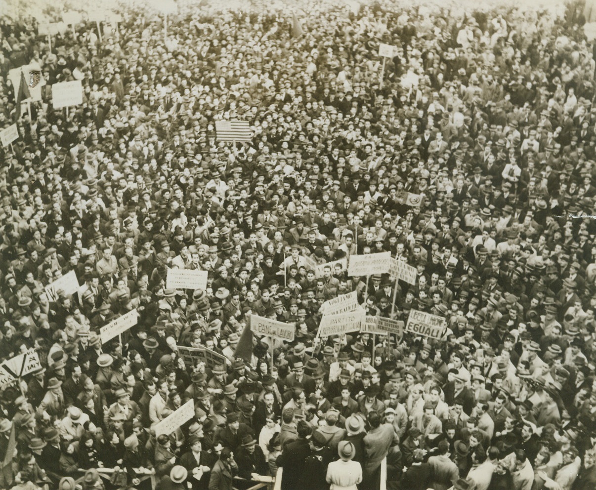 Protest Demonstration, 3/29/1940. NAPLES, ITALY -- This demonstration took the place of the planned 10-minute strike, abandoned in favor of the Allies war effort by the Italians in Naples. The vast throng of socialist, communist and action party members staged the demonstration on Sunday, March 12 against the Allies' support of the Badoglio Government of Italy. The American flag can be seen among the posters in the background. Credit Line (ACME);